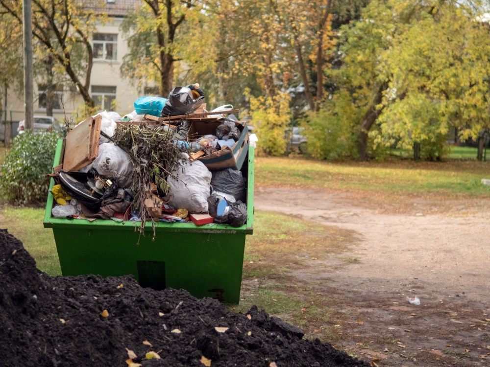 green skip pilled high with rubbish